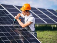 Man worker in the firld by the solar installers